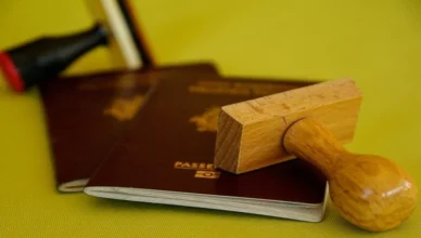 Passport on table with wooden stamp