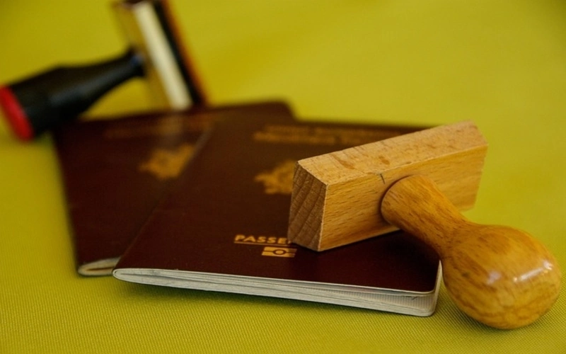 Passport on table with wooden stamp