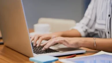 Women typing on a laptop while checking visa information online