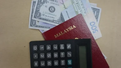 Malaysian passport with currency notes and calculator