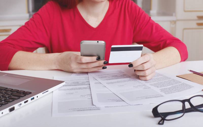 Woman checking online bank statement using smartphone 
