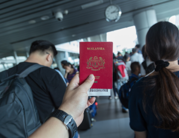 Malaysia visa page inside a passport with immigration stamps